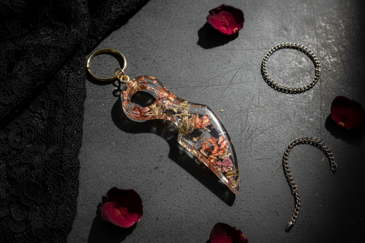 Clear resin dagger keychain on dark gothic table